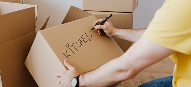 man labeling cardboard boxes