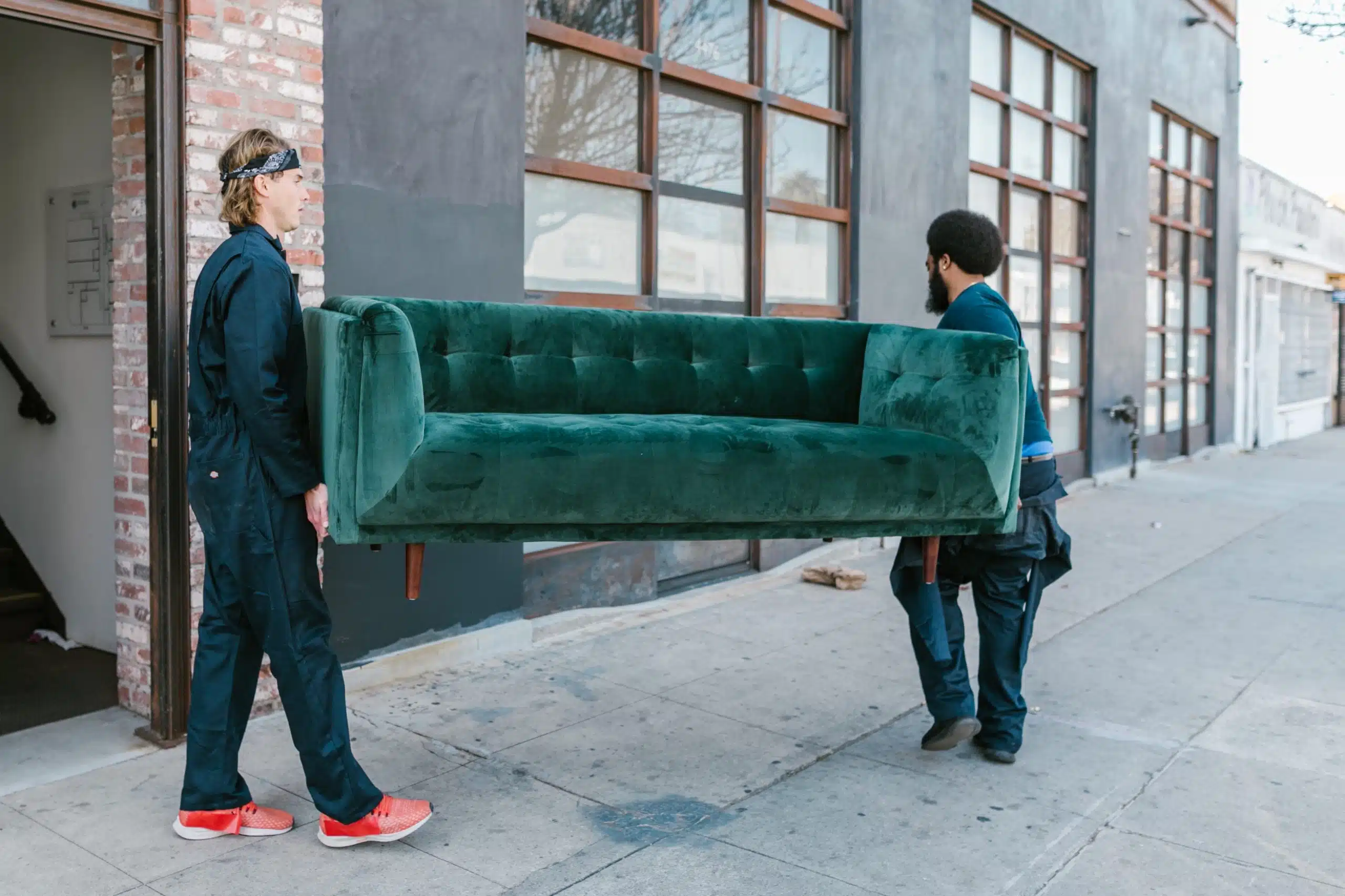 two men moving a large sofa