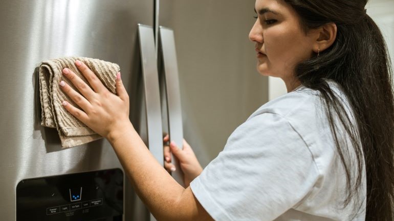 a woman cleaning the fridge 