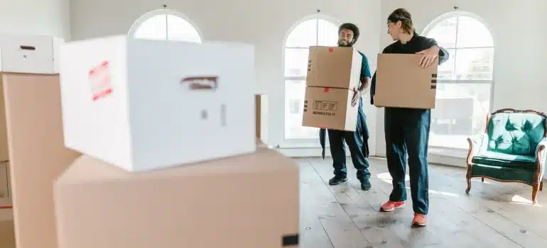 Two men carrying boxes