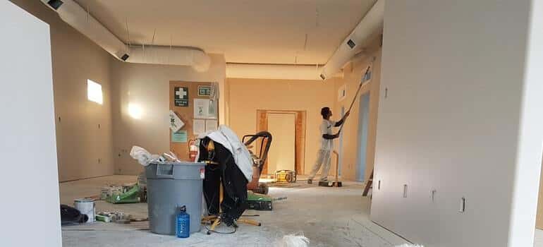 person painting a wall and thinking of renting a storage unit during renovation