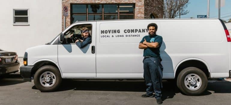 man standing in front of moving company van