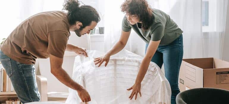 A couple trying to prepare expensive furniture for storage