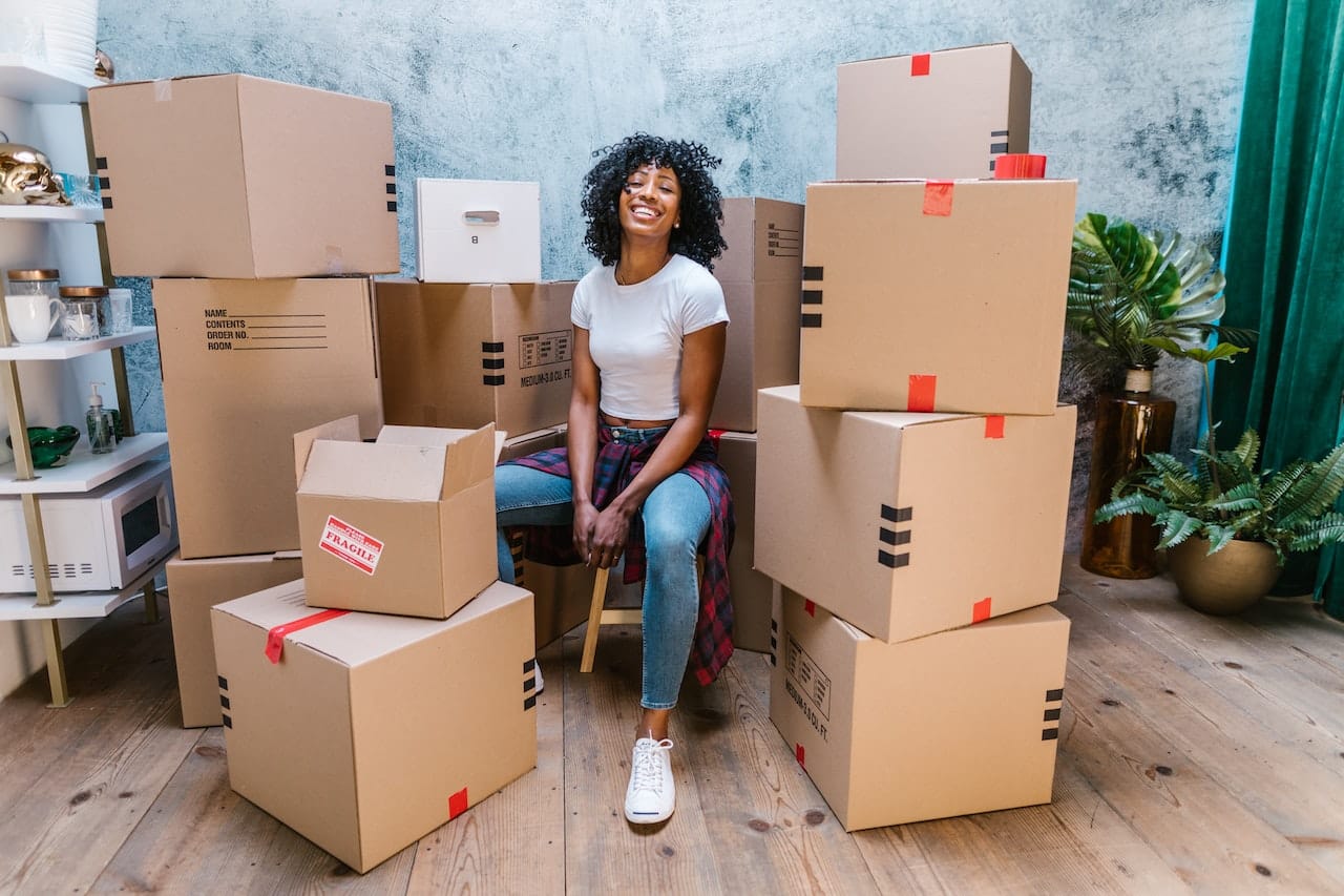 A woman surrounded by boxes trying to get ready for move-in day this fall