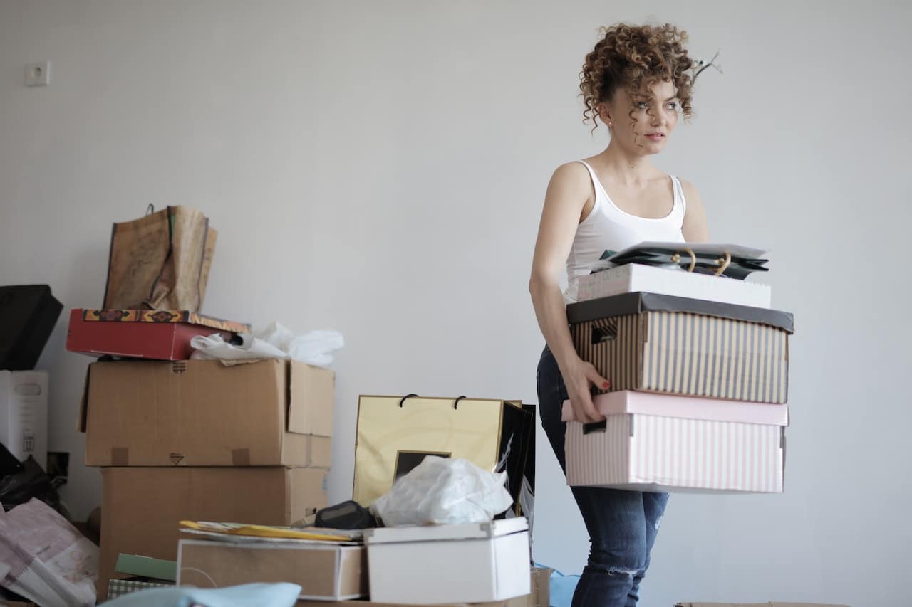A woman packing her stuff for a move and thinking of Pros and cons of living in Rochester