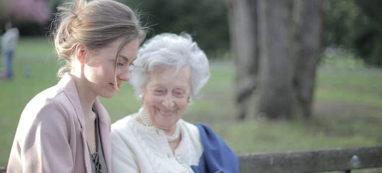 A woman with her mother showing her how to use a smartphone