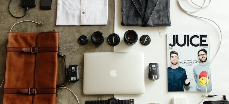 Brown Leather Bag, some clothes and a laptop someone is packing