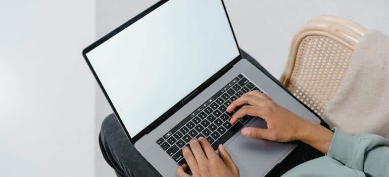 A person typing on their laptop